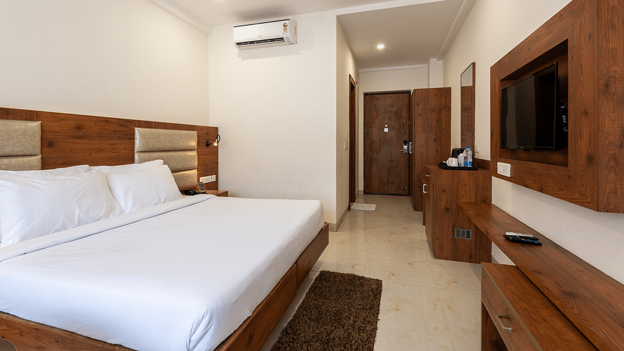Side view of a Premium Room featuring a television, wooden wardrobe, and air-conditioner at DLS The Classio